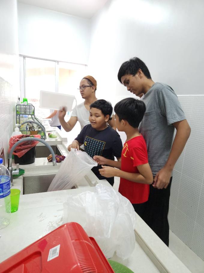 Pelajar membantu menyediakan makanan di dapur