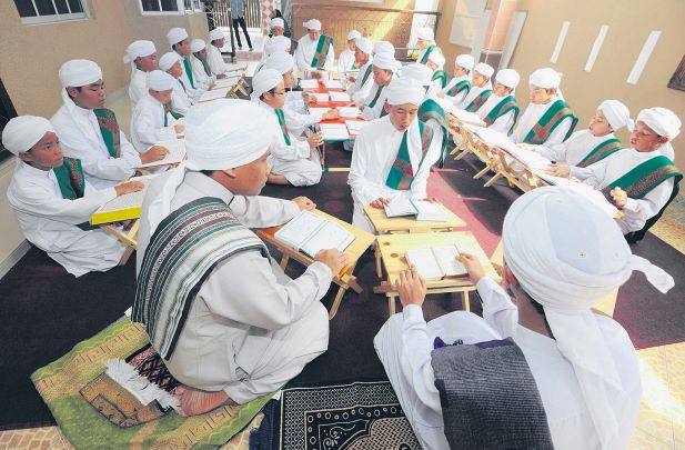 Pelajar bertudung putih membaca Al-Quran bersama-sama