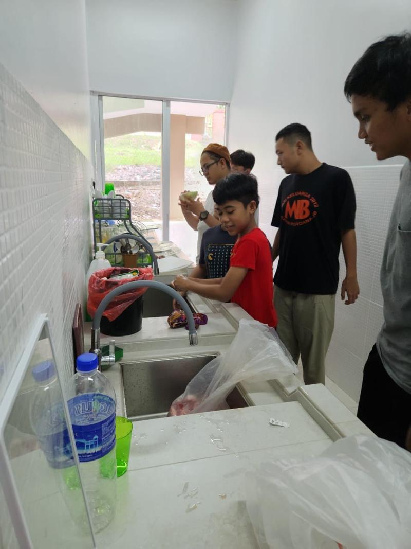 Anak-anak membantu membasuh di ruang dapur
