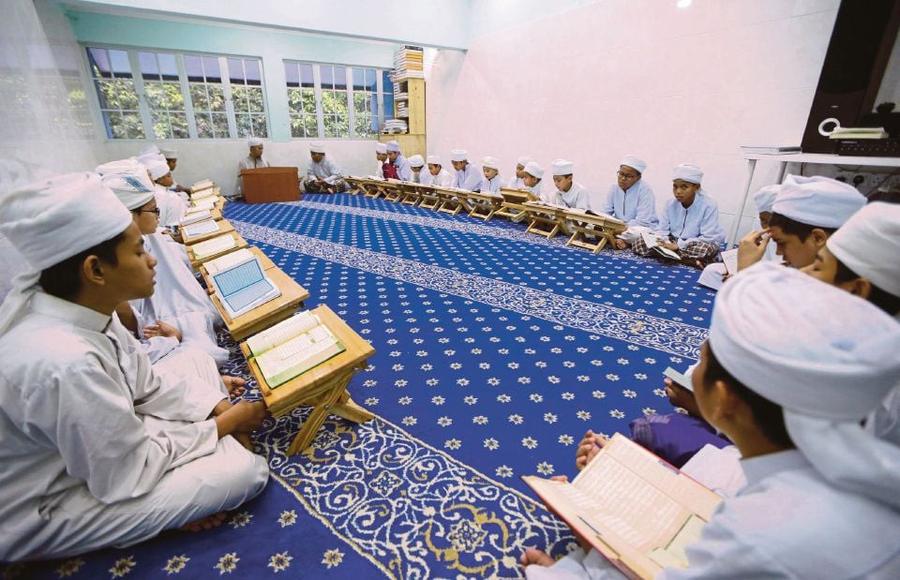 Seorang pelajar membaca Al-Quran di ruang solat