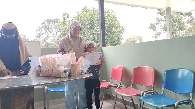 Sukarelawan wanita membungkus sumbangan untuk diagihkan